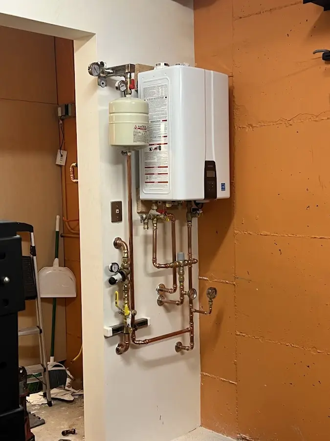 Plumbing technician inspecting water heater connections in Waianae